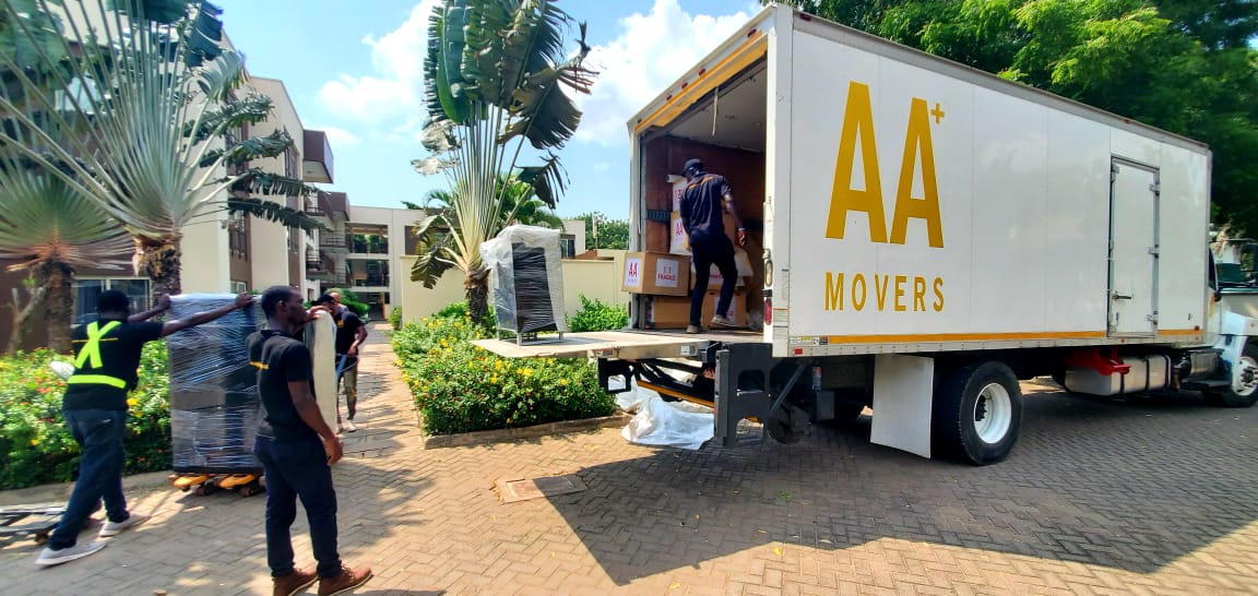 AA+ Movers offloading furniture with a tail lift and pallet truck at a new apartment in Verola Court, Cantonments, Accra, showcasing our professional moving services in Ghana