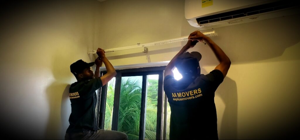 Two AA+ Movers professionals in uniform providing Relocation Handyman Services while installing a curtain track in a new home post-move