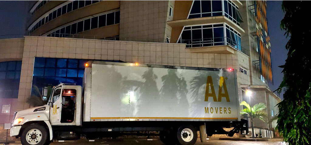 AA+ Movers' 24-foot truck with a tail lift parked outside Advantage Place, Ridge Accra, during an office relocation