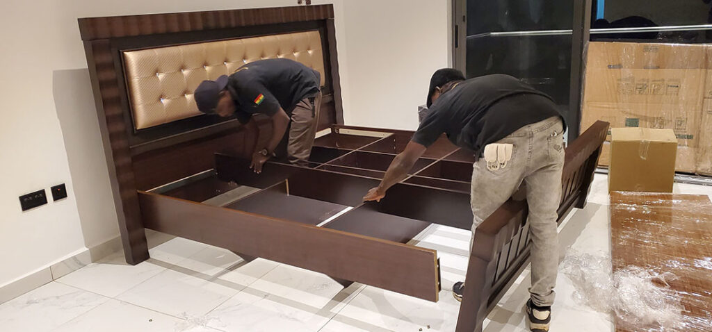 Two AA+ Movers professionals reassembling a bed in East Legon, Accra, providing expert relocation handyman services