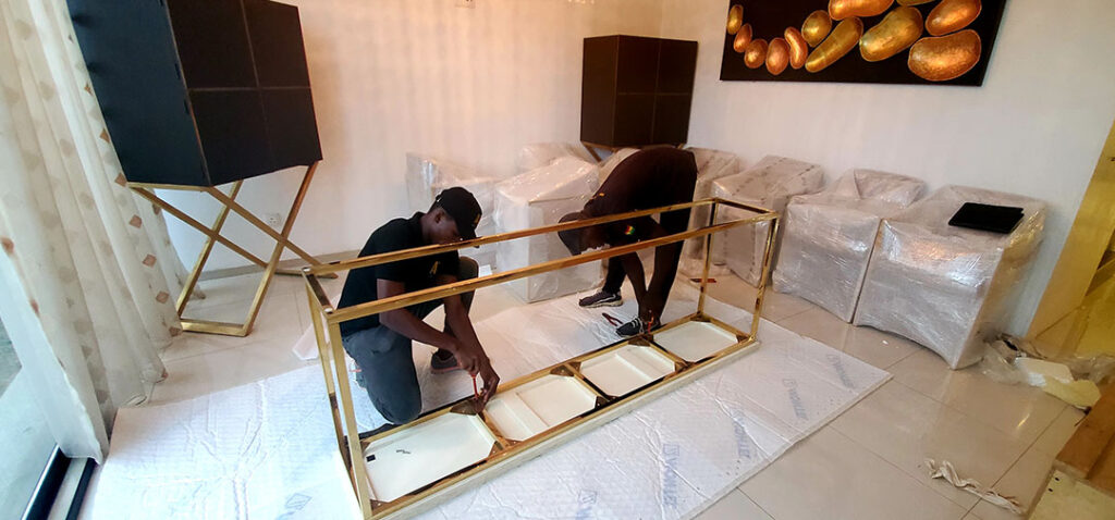 AA+ Movers team unscrewing a marble stand on bubble wrap during preparation for storage as part of our professional moving services in Ghana